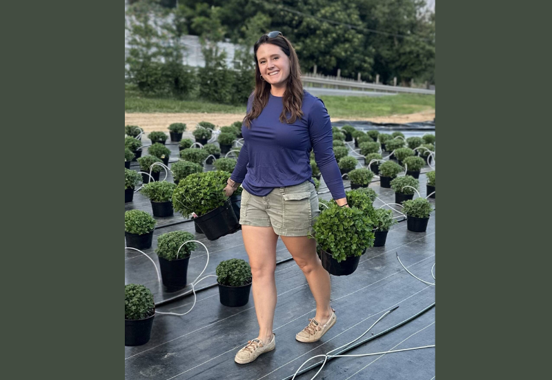 image of GPN's Forty under 40 winner Class of 2025: Mallory Baslee carrying potted plants.