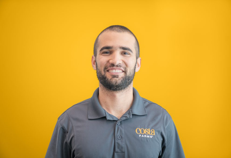 A man smiling with a yellow background