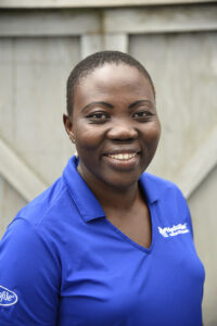 Women in a blue shirt smiling for a photo