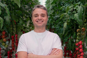 man in white shirt with arms crossed and smiling