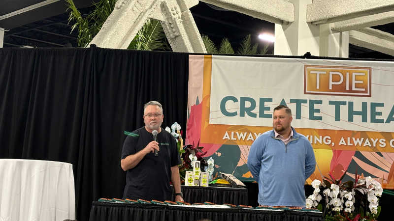 TPIE Cool Product Award ceremony with two men standing on a stage with a microphone