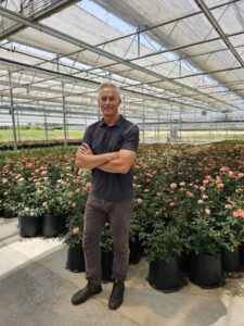 : Ken James is shown here with Rosa ‘Knock Out Coral’3-gallon stock pots in the background.