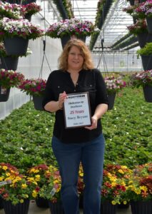 Stacy Bryant holding an award of recognition