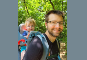 image of GPN's Forty under 40 winner Class of 2025 Jason Henry with his son in a backpack carrier