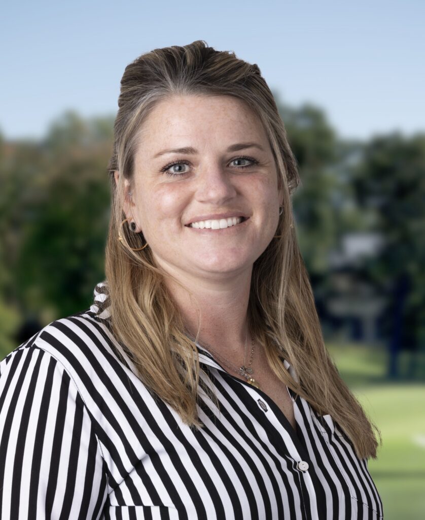 headshot of smiling woman wearing a black and white vertically striped shirt.