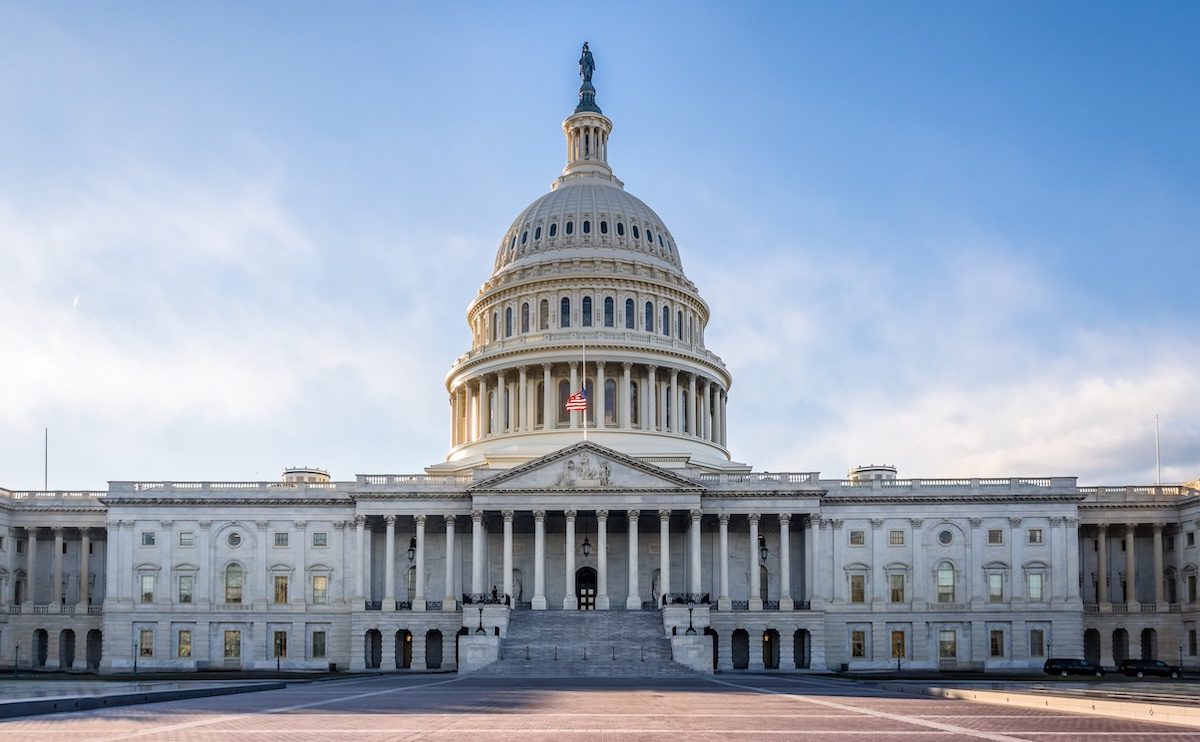 The US Capitol building silhouetted against a blue sky