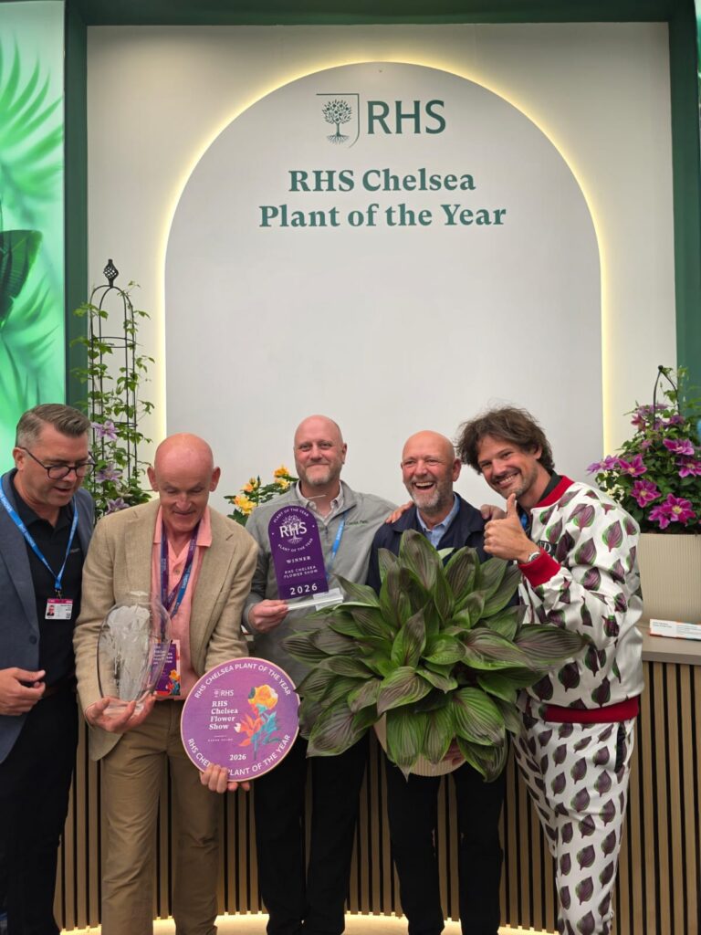 group of people smiling with awards and holding a hosta plant