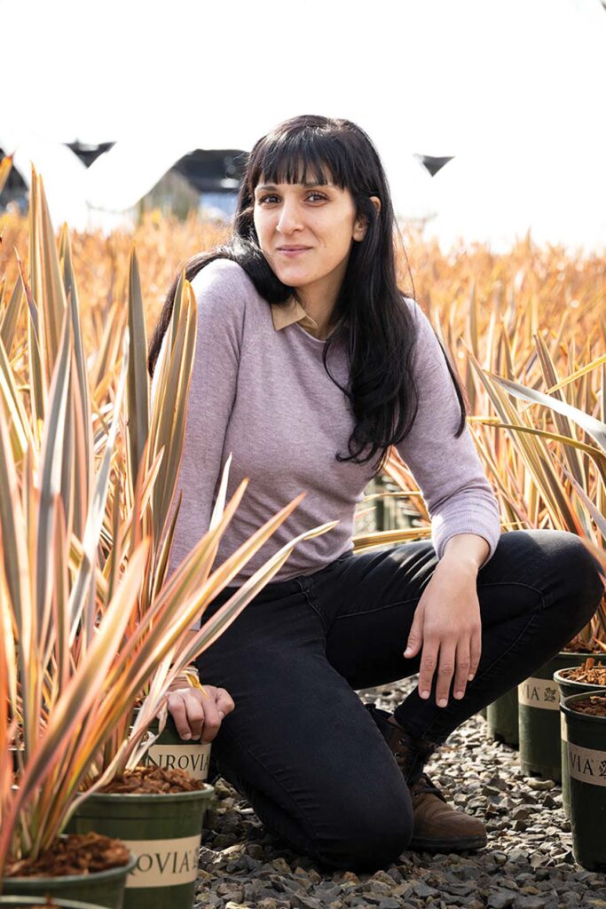 smiling woman sitting among plants