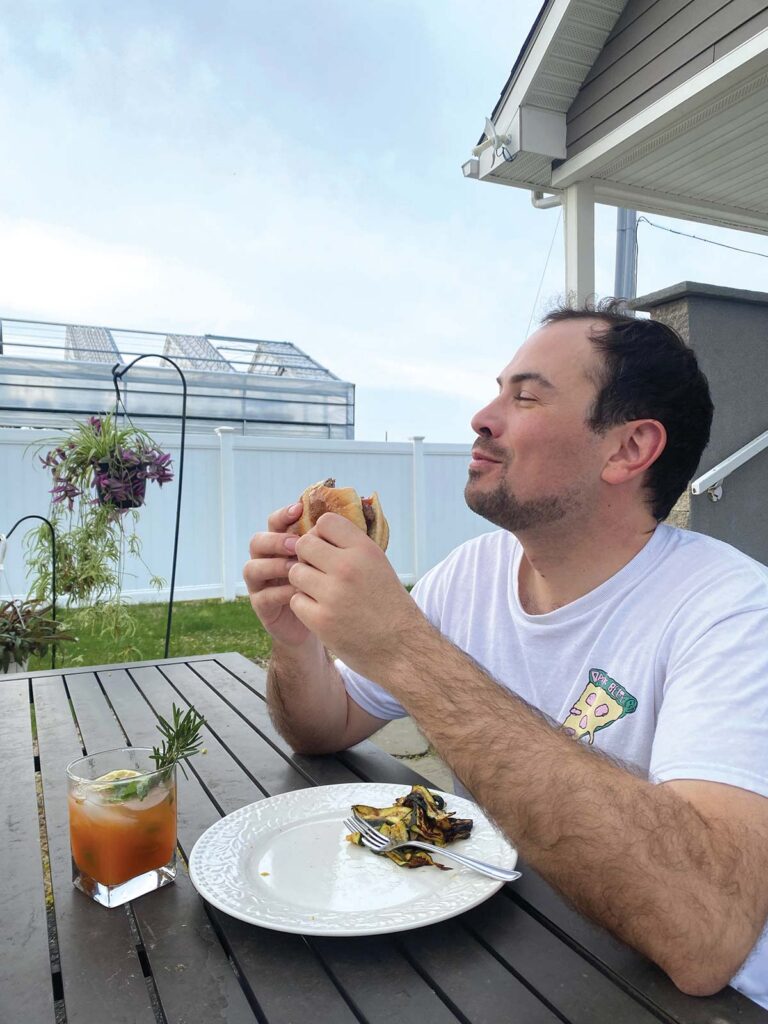 man sitting at table with plate of food eating
