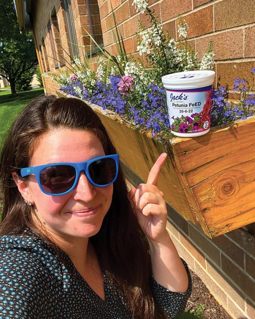 woman where sunglasses pointing to fertilizer product
