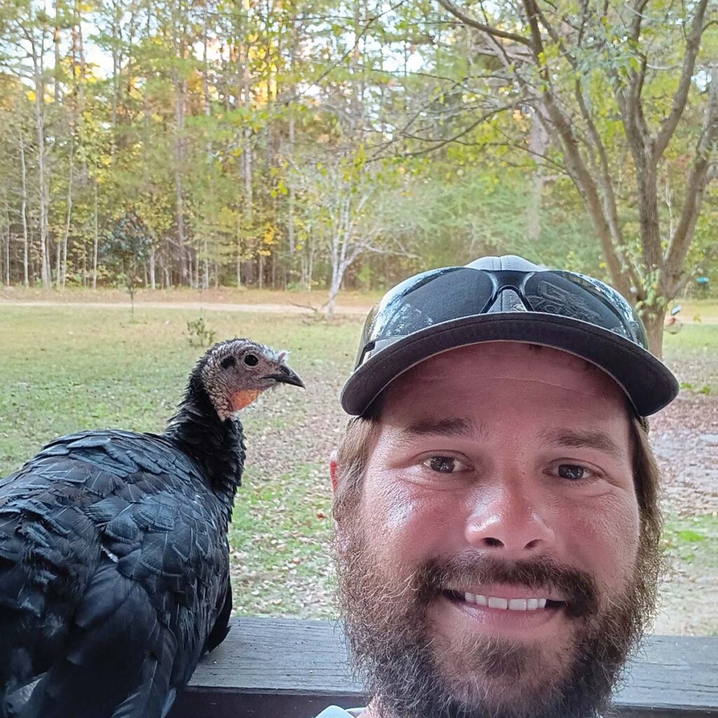 man smiling next to turkey