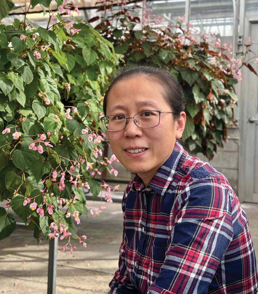 smiling woman with plants in background
